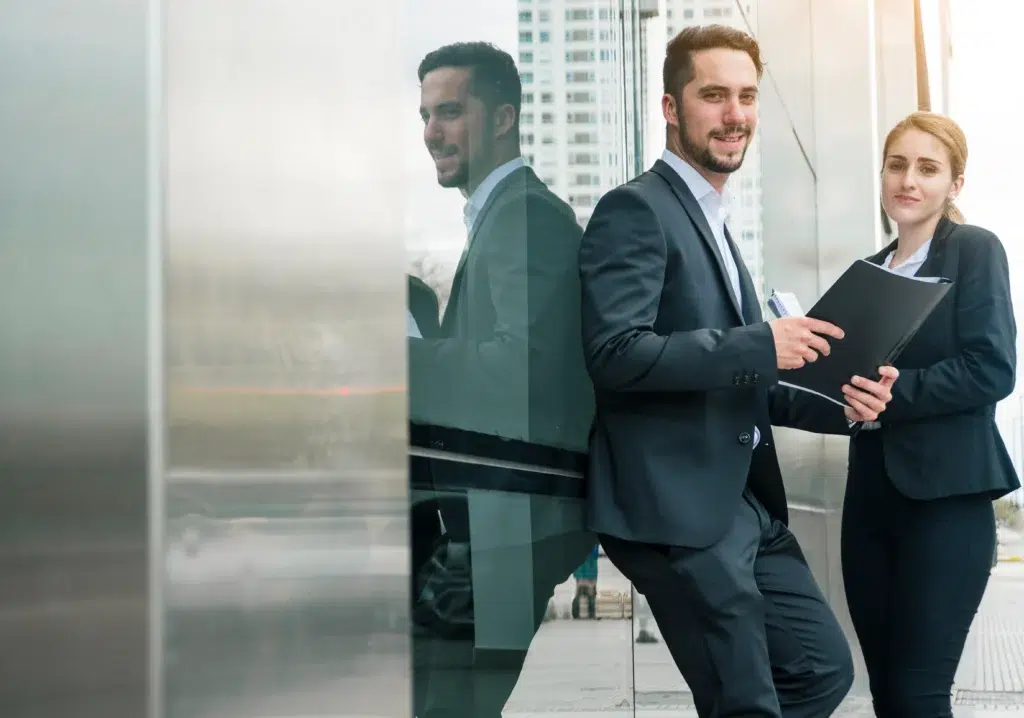 portrait young businessman holding folder hand standing with her female s colleague outdoors