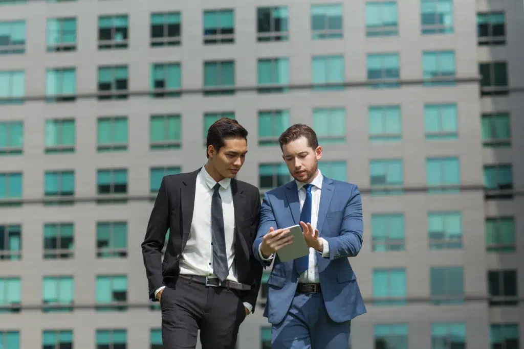 two content business men using tablet walking